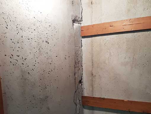 Basement-Wall-Corner-Crack-Repair Corner crack in a poured concrete basement wall extending from the floor joint upward along the corner.